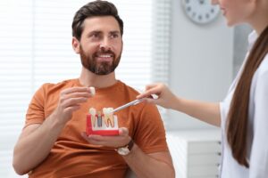 Man with a beard talking to his dentist about dental implants